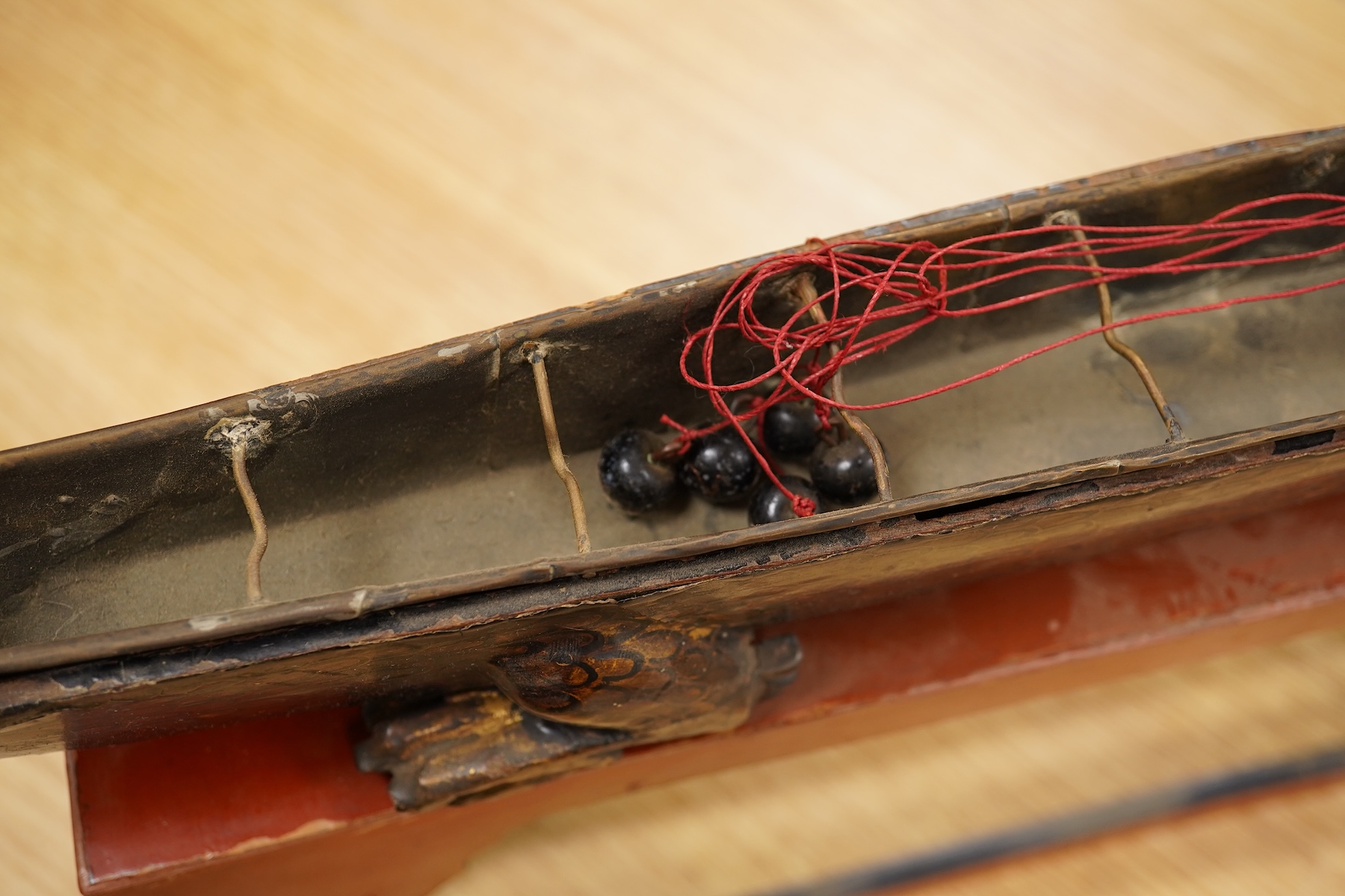 A South East Asian gilt decorated black lacquer model 'dragon' boat on stand, 75cm